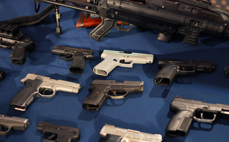 Confiscated guns are displayed on a table at a public safety news conference at City Hall in New York City on June 3. In a recent study, researchers found more pediatric firearm deaths in states with looser gun laws. (Photo by Michael M. Santiago/Getty Images