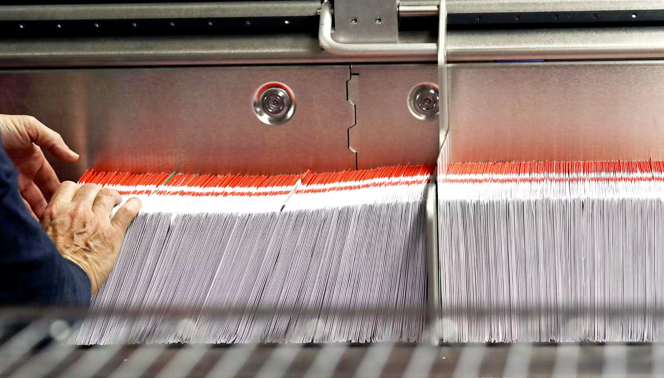 FILE - This Nov. 7, 2018, file photo shows an election worker stacking ballots into a sorting machine at the King County Elections office in Renton, Wash. (AP Photo/Elaine Thompson, File)