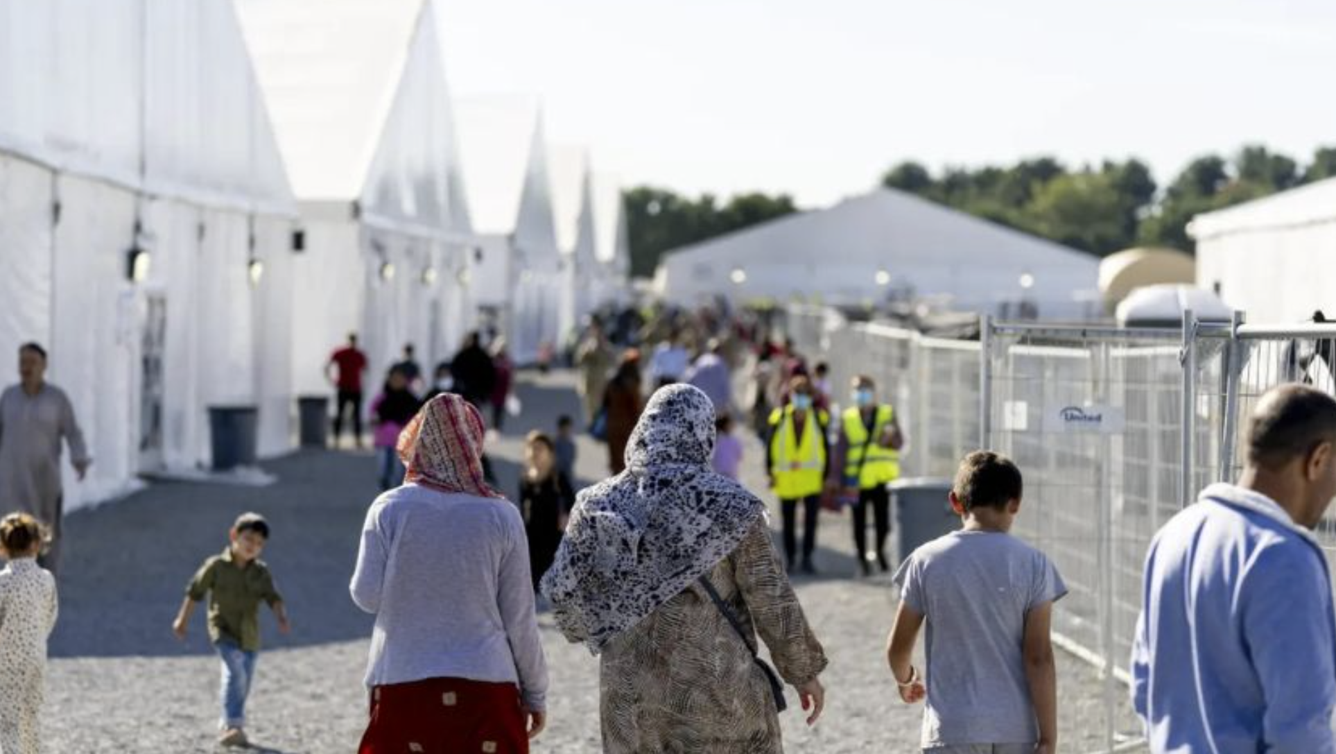 Afghan refugees walk through an Afghan refugee camp at Joint Base McGuire Dix. (Photo: Andrew Harnik, The Associated Press)