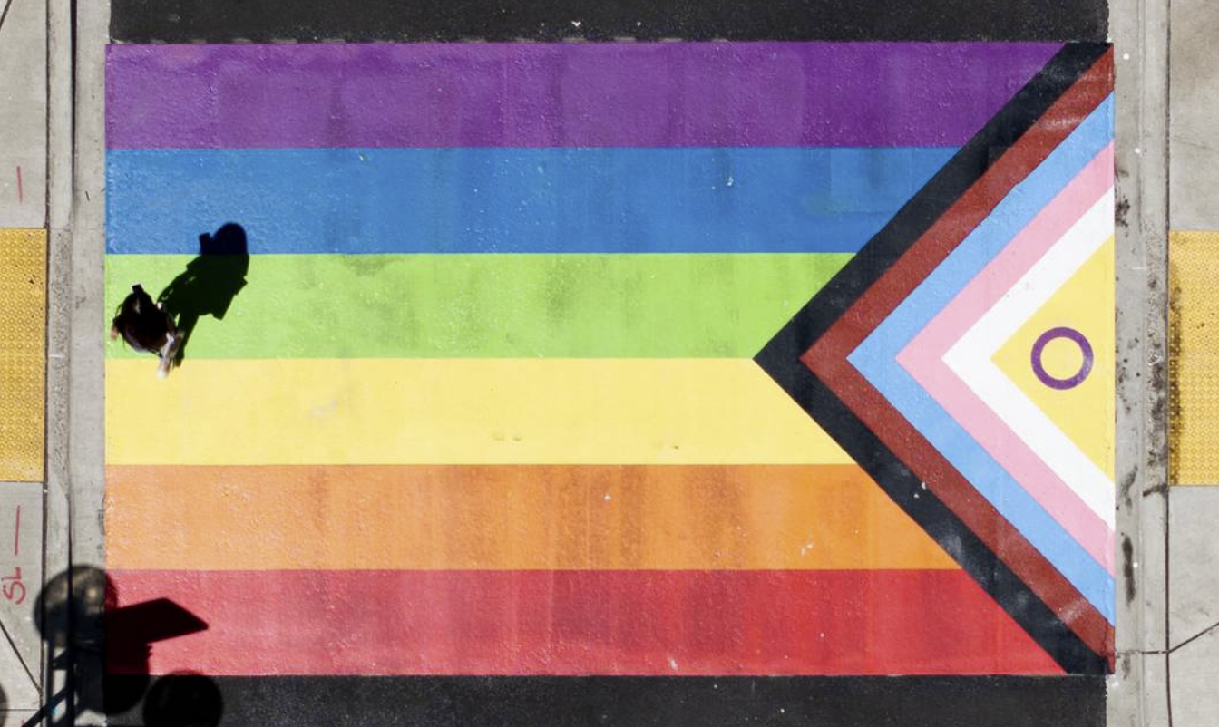 A person walks across the newly painted Pride Flag crosswalk mural in Tacoma, Wash. Liesbeth Powers lpowers@thenewstribune.com