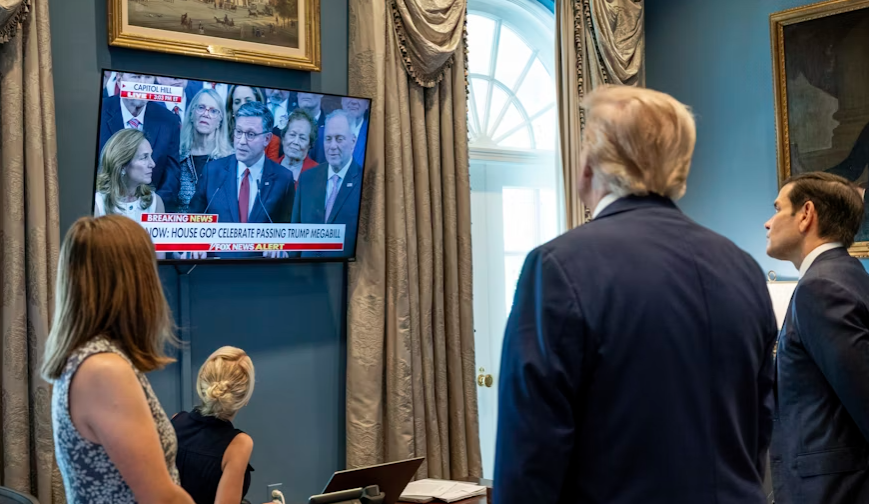 In this image provided by The White House, President Donald Trump and Secretary of State Marco Rubio watch Speaker of the House Mike Johnson on television in the Outer Oval Office of the White House in Washington, after the House passed the 