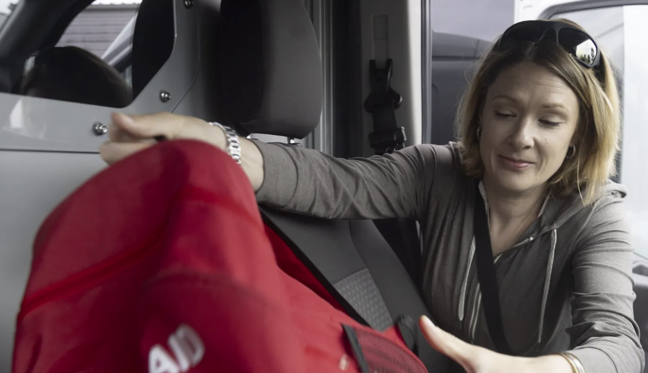 April Coberly, a case manager with Sound Behavioral Health, loads a first aid kit and supplies into a mobile crisis team van at the organization’s office in Auburn last month. (Akash Pamarthy / The Seattle Times)