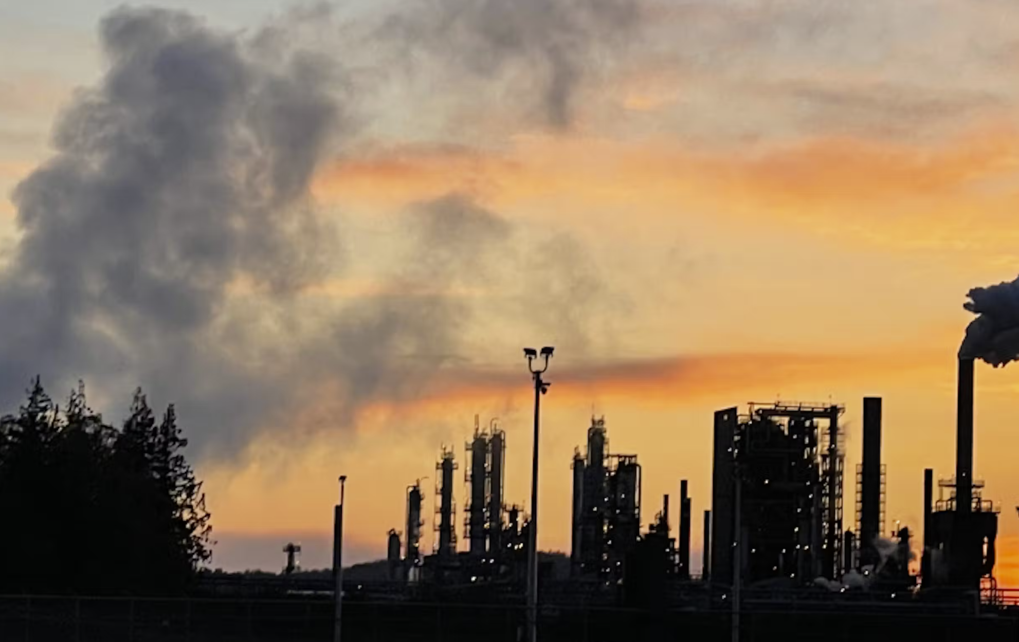 The sun sets behind the Marathon Petroleum refinery in Anacortes in April 2022.