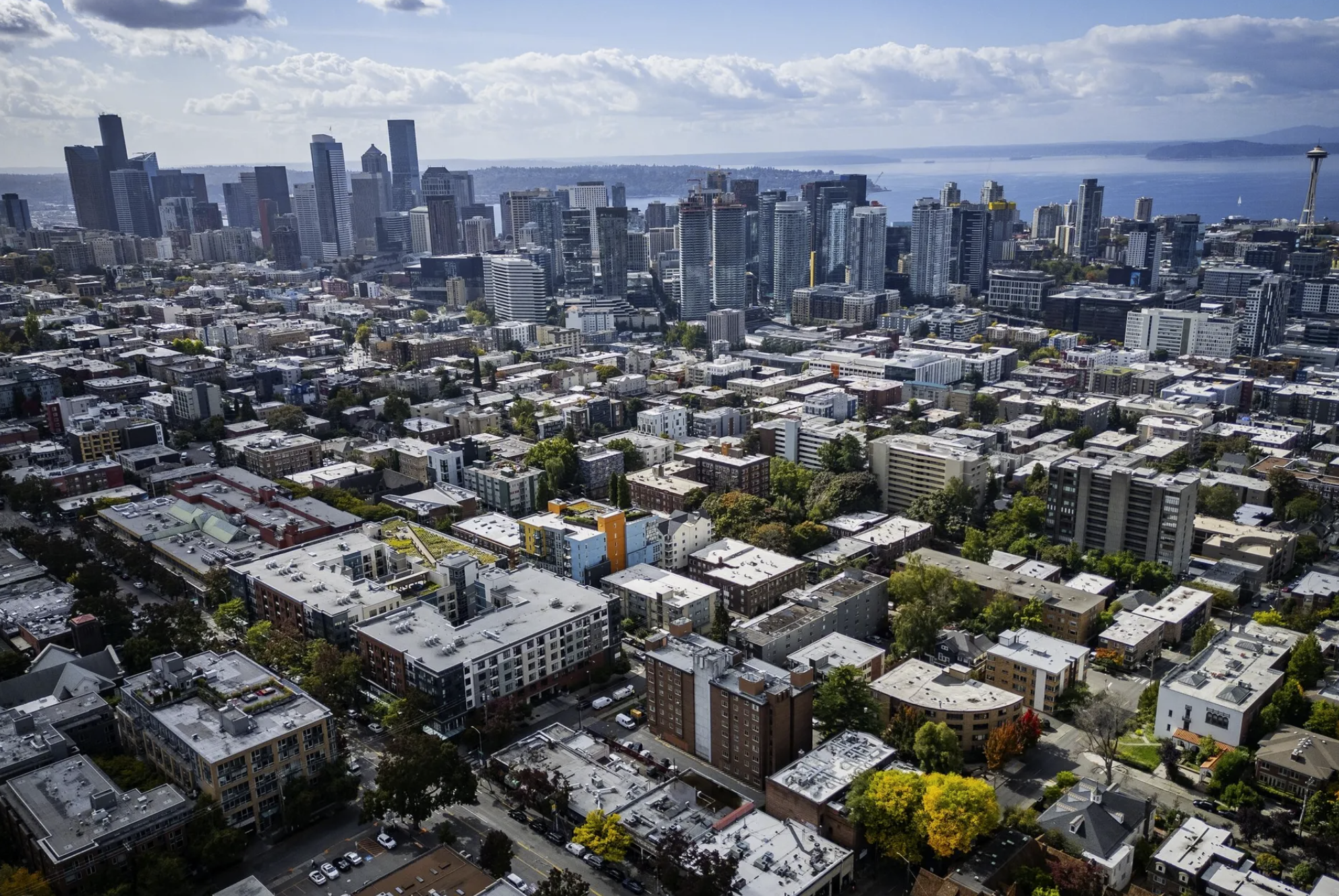 Capitol Hill apartments spread out as far as the eye can see, with downtown Seattle and Puget Sound in the background. The maximum rent increase for most rentals for the rest of this year is 10% under Washington’s new law. (Ken Lambert / The Seattle Times, file)