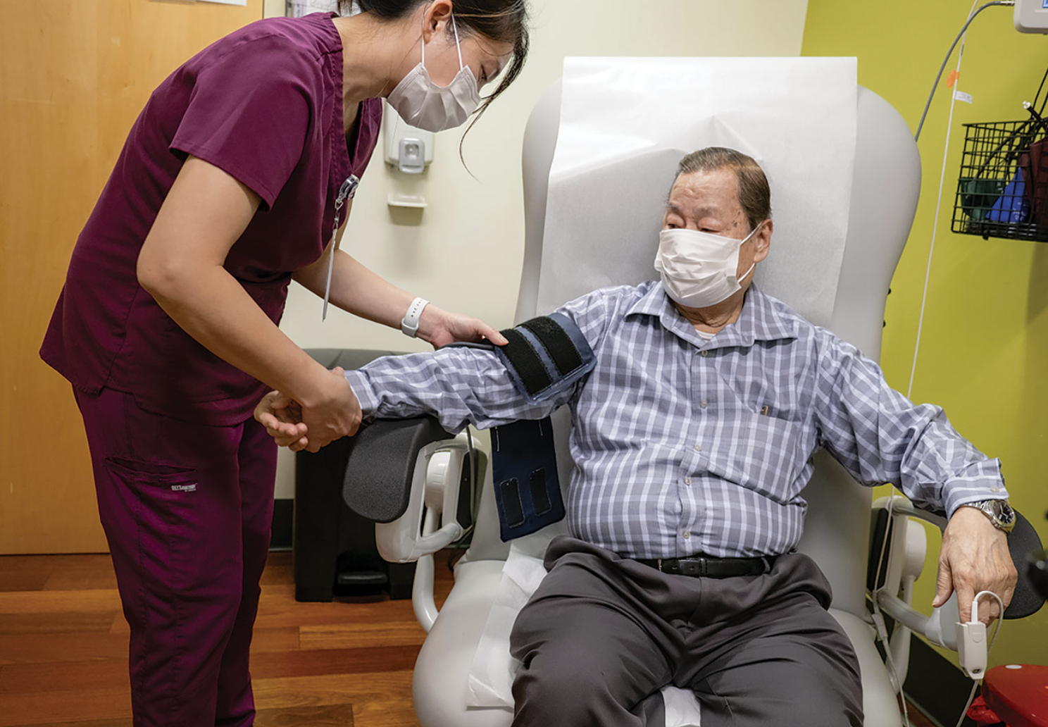 ICHS Lead Medical Assistant Anh Nguyen fits a blood pressure cuff on an elderly patient. Photo courtesy of ICHS.