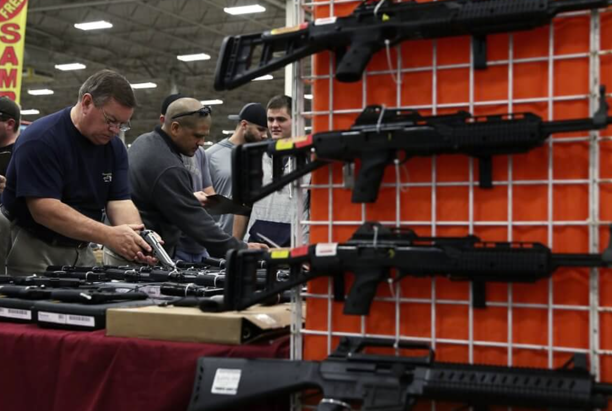 Potential buyers try out guns which are displayed on an exhibitor’s table during the Nation’s Gun Show on Nov. 18, 2016 at Dulles Expo Center in Chantilly, Virginia. (Photo by Alex Wong/Getty Images)