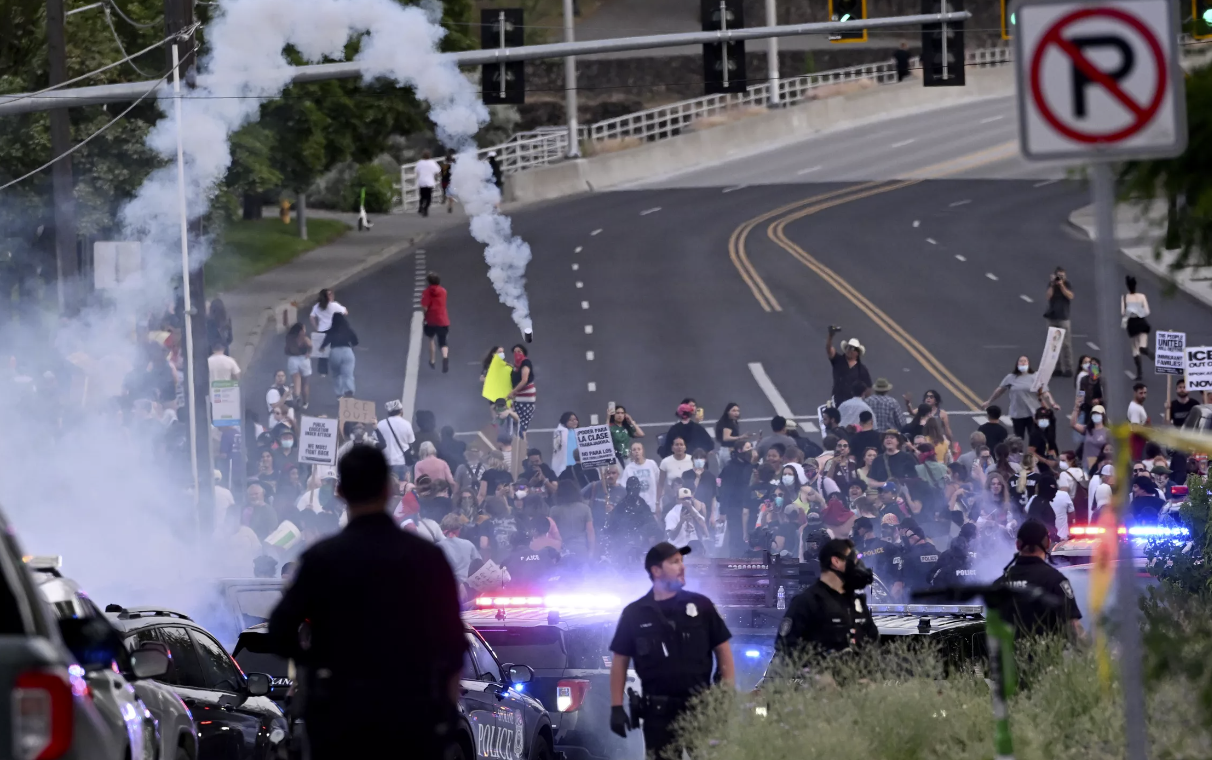 After a large group of Spokane Police Department secured the area around the ICE office, the larger group showed up and were dispersed by smoke cannisters and pepper balls. (Jesse Tinsley/THE SPOKESMAN-REVIEW)