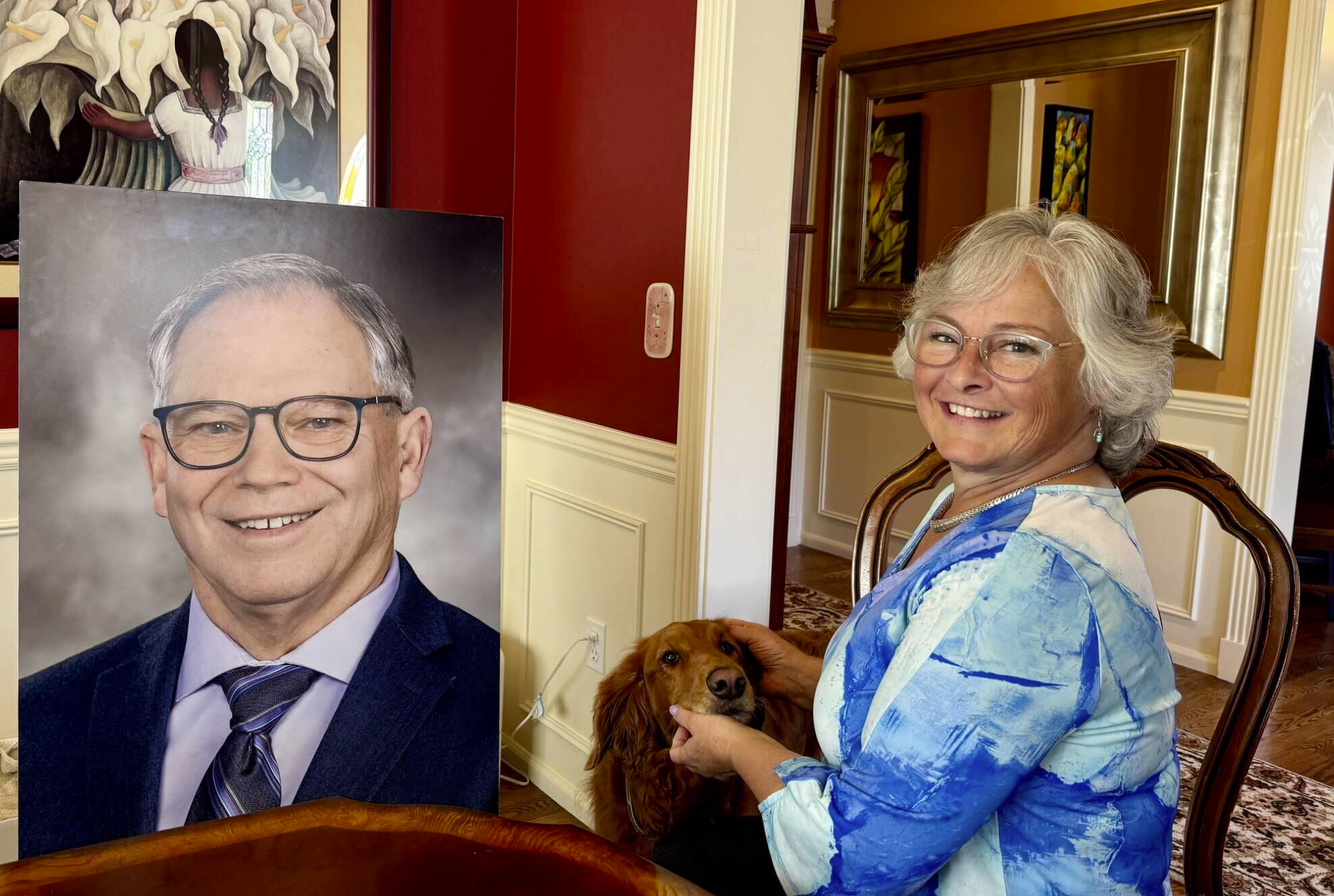 Sarah Perry and her dog, Sadie, sit with the photo of Bill Ramos used for his celebration of life in their Issaquah home, July 30, 2025. Perry said she keeps the photo in her home office so Ramos is always with her. (Grace Gorenflo/Valley Record)