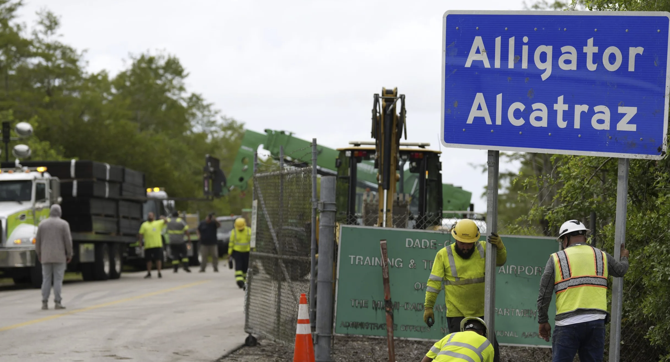 Workers install a sign reading 
