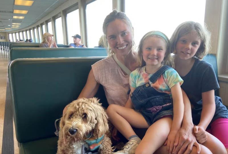 Bridget Igoe (left) travels with her daughters Julia (center) and Helen (right) with their dog Juniper from Bainbridge to Seattle aboard the Walla Walla passenger ferry. Noel Gasca / KUOW Photo