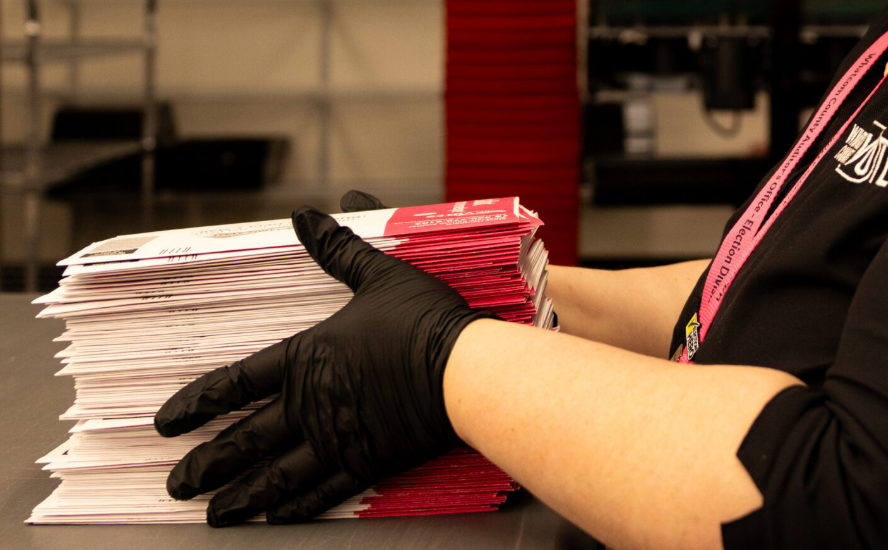 Laurie Dawson organizes a pile of ballots during primary election day, Aug. 5, in Bellingham. (Santiago Ochoa/Cascadia Daily News)