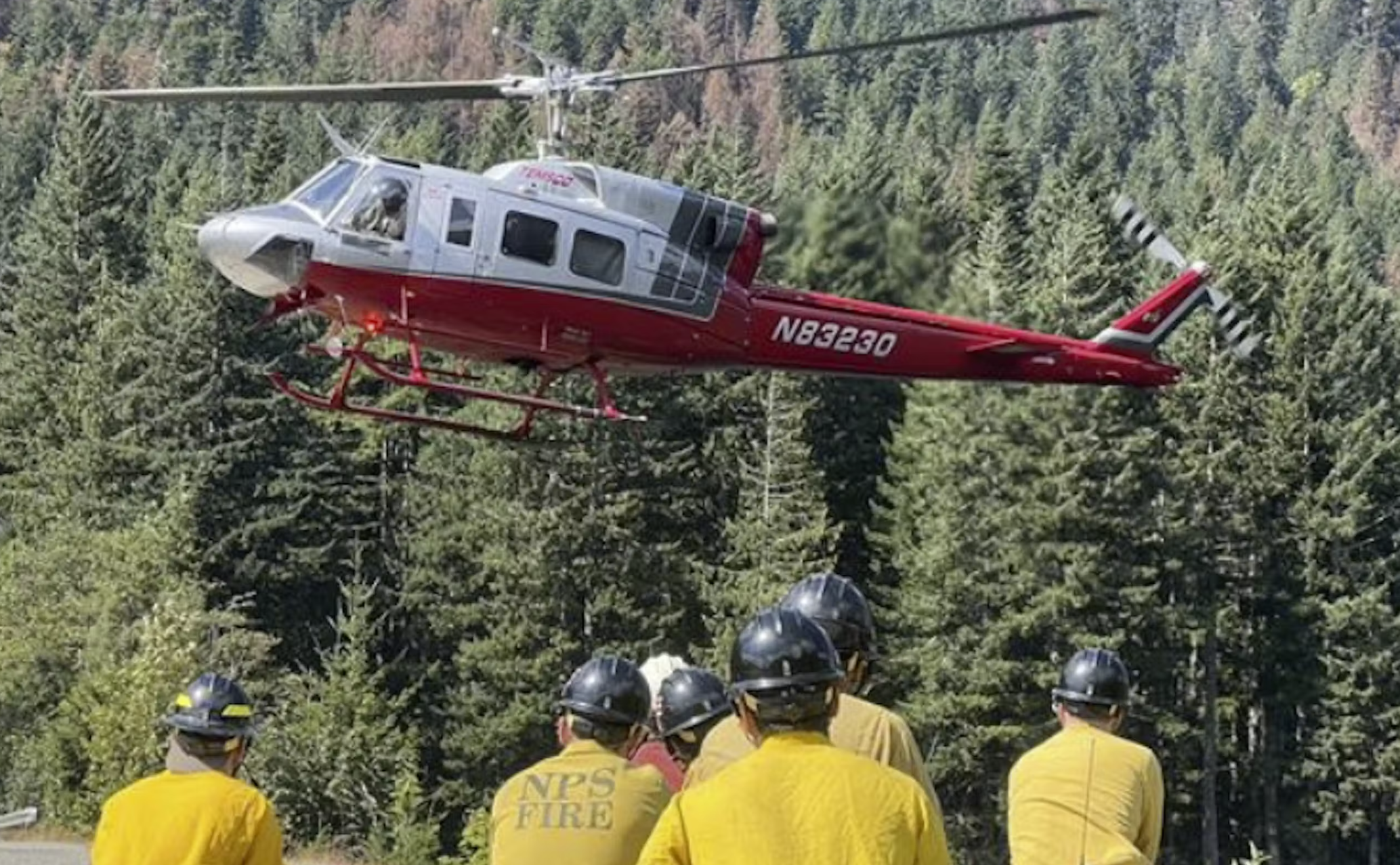 On Aug. 24, 2025, firefighters working on the Bear Gulch wildfire in the Olympic National Forest wait for a helicopter shuttle.