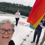 Rep. Jinkins selfie on top of Tacoma Dome with Pride flag