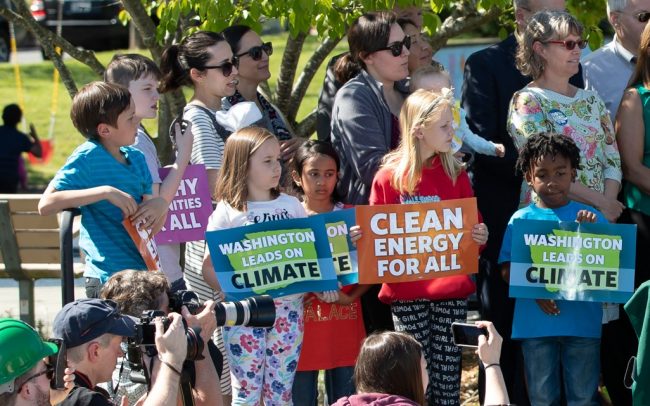 Children standing with signs in a crowd at rally