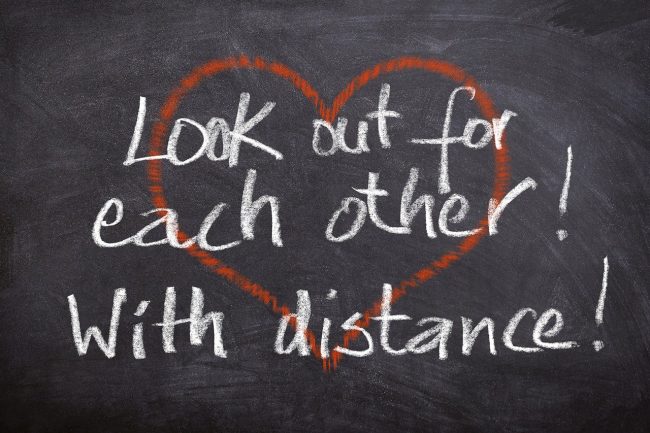 Red heart on chalkboard with "Look out for each other! With distance!" written over it