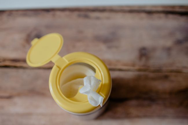 Open container of disinfectant wipes with yellow plastic top