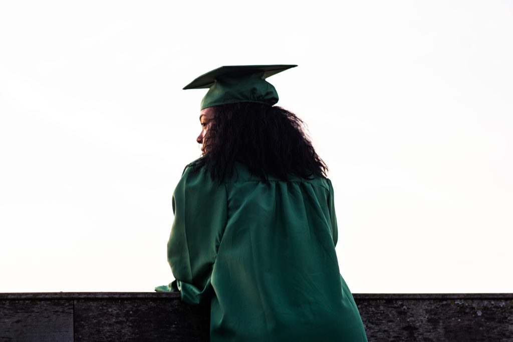 Woman graduate in green robe from back