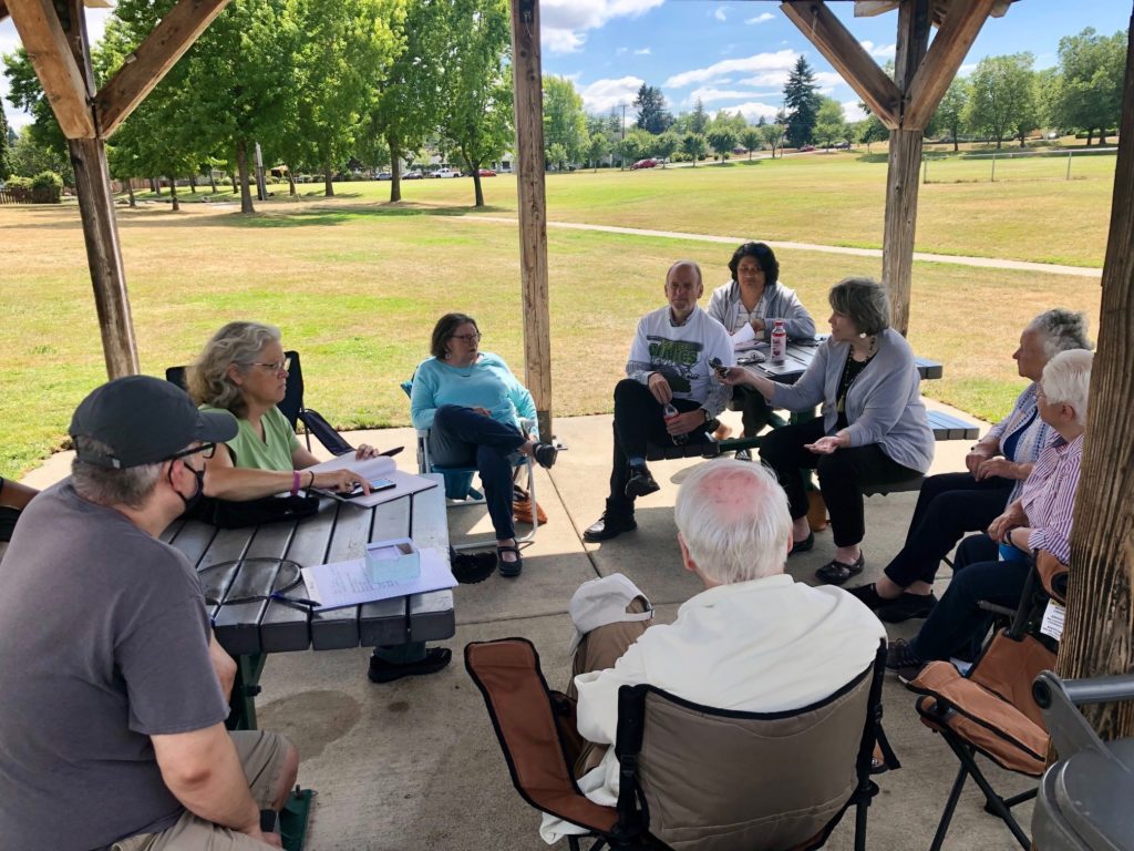 Legislators under picnic shelter chatting with constituents