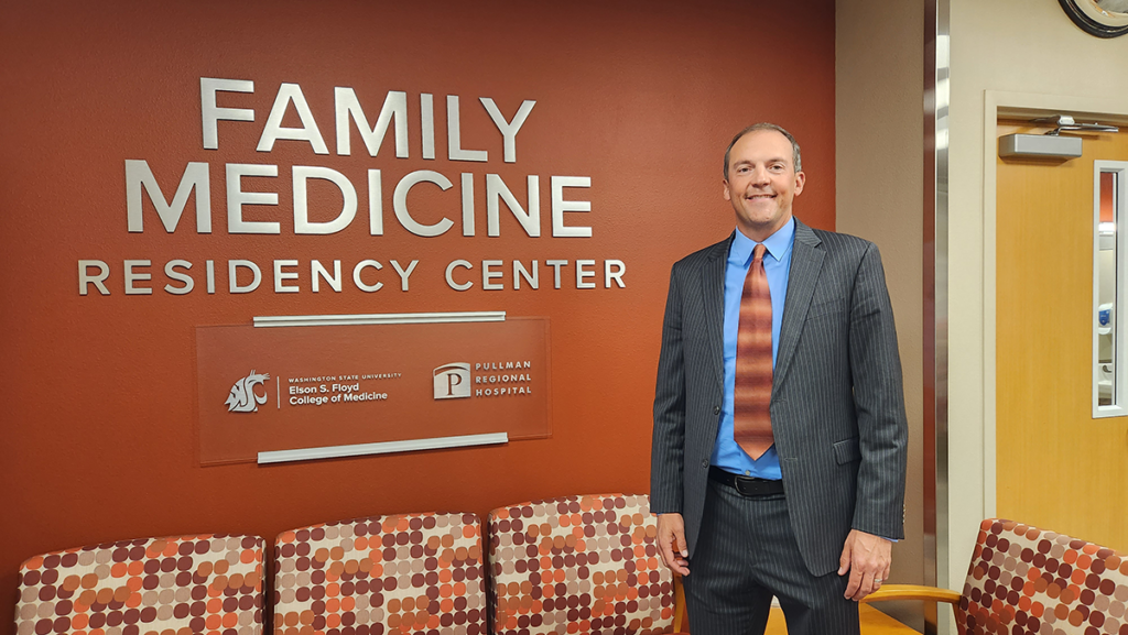 Rep. Marcus Riccelli standing in front of a wall with a sign that says FAMILY MEDICINE RESIDENCY CENTER WASHINGTON STATE UNIVERSITY ELSON S. FLOYD COLLEGE OF MEDICINE and PULLMAN REGIONAL HOSPITAL