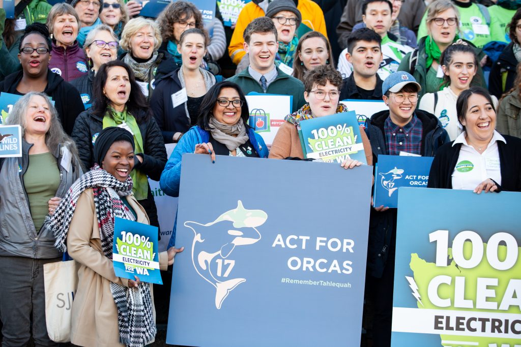 Participants at the Environmental Priorities Coalition Rally, holding signs on capitol steps