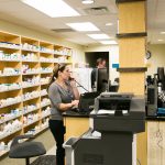 Photo of pharmacy workers taking calls and filling prescriptions