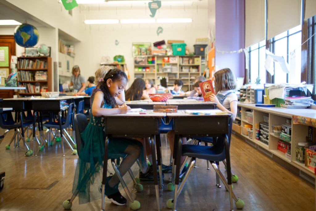 Elementary aged students at desks in a classroom working on assignments
