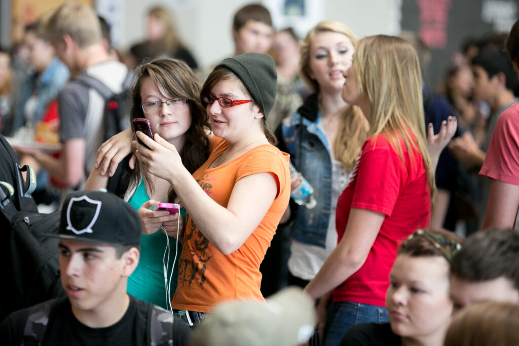 Students interacting in a High School lunch room.