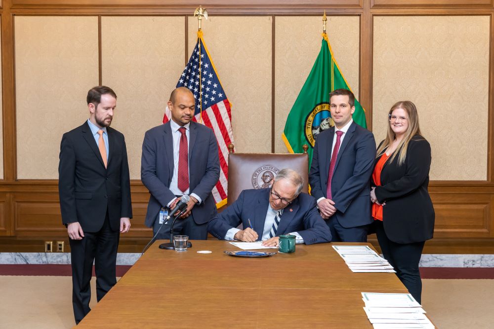 Gov. Inslee signs the bill as Rep. Street watches